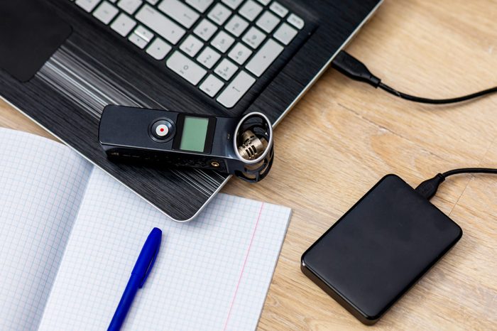 journalist's work at a computer with a voice recorder and laptop