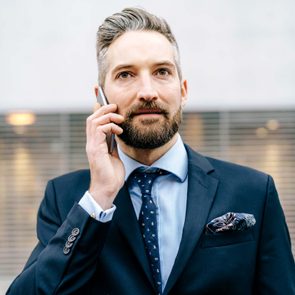 man holding up cell phone to his ear