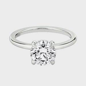 A sparkling diamond ring rests against a plain gray background, featuring a polished band with 