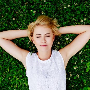 Portrait of a young woman lying on the grass