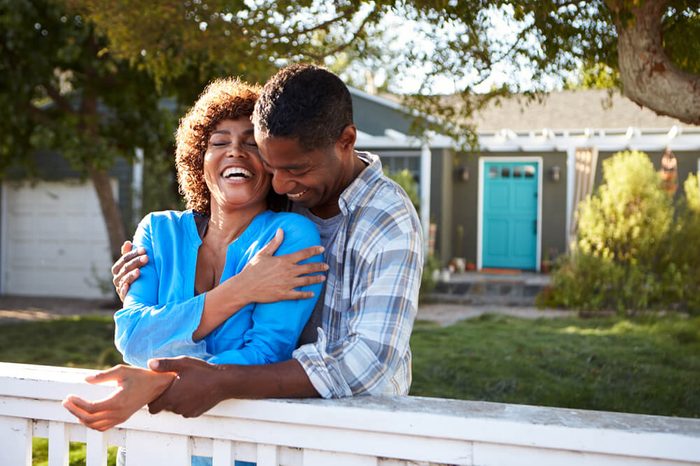 Mature Couple Leaning On Back Yard Fence
