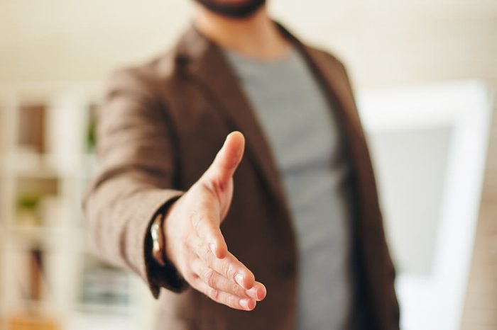 Businessman giving his hand for handshake to partner