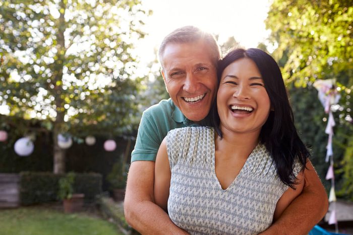 Portrait Of Loving Mature Couple In Back Yard Garden