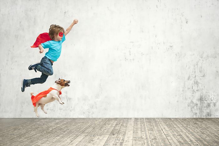 boy and his adorable puppy wear matching superhero capes