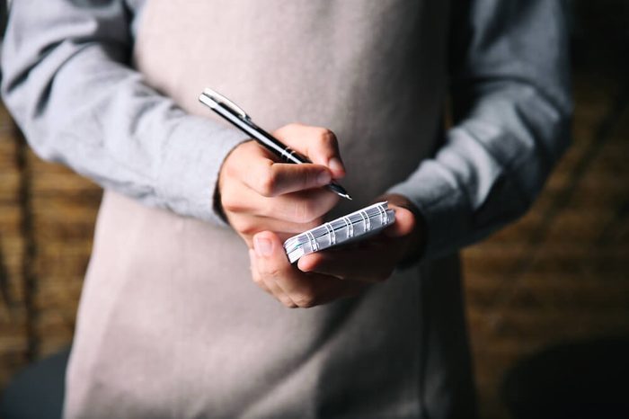 Waiter writing an order into a notebook