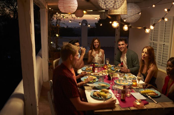 Friends talking at a dinner party on a patio, Ibiza, Spain