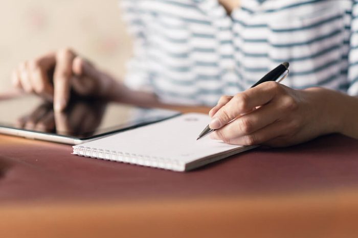 Woman Writing in a Notebook. Selective focus small depth of field and natural light.