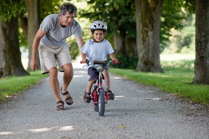 Father teaching his son to ride a bike