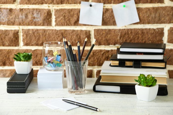 Stylish workplace at home or studio, on brown bricks background