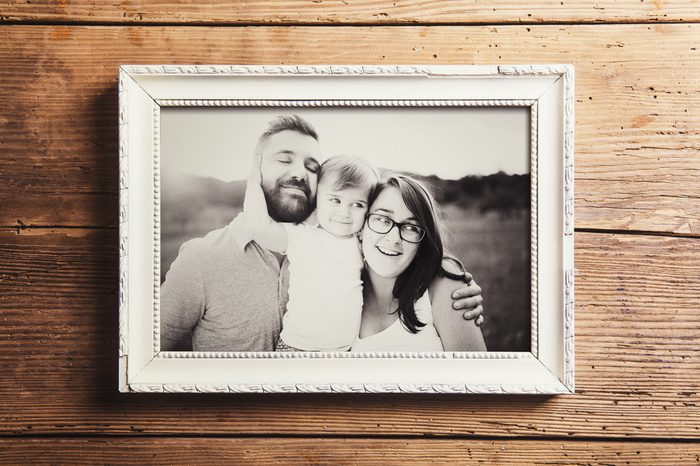 Fathers day composition - picture frame with a black and white photo. Studio shot on wooden background.