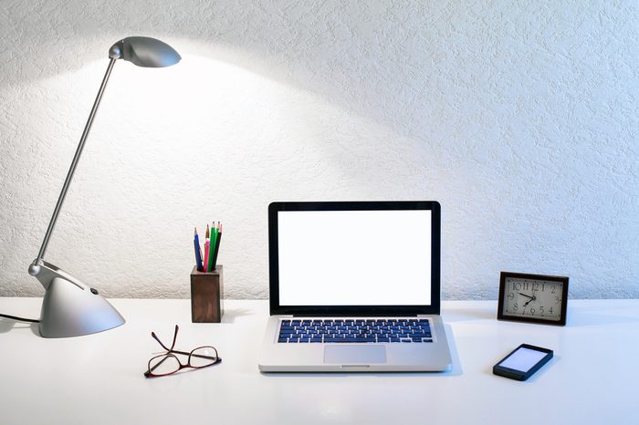 office workplace of business person, table with laptop and lamp
