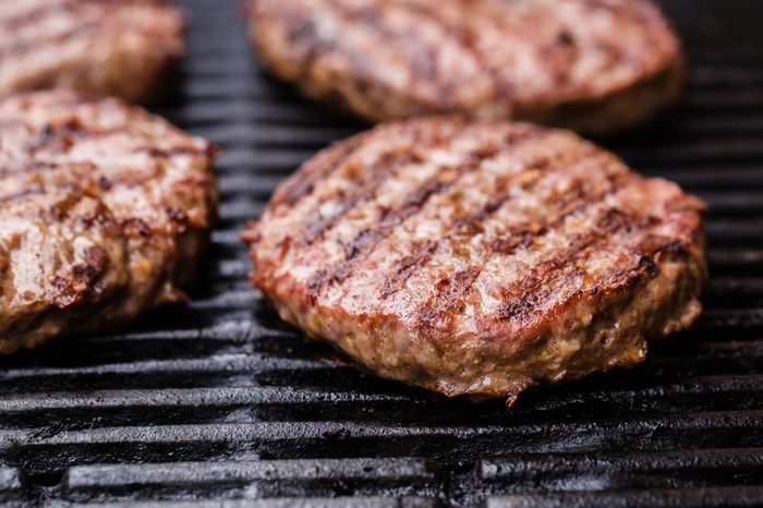 Preparing a batch of ground beef patties or frikadeller on grill or BBQ