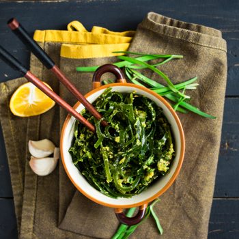 Japanese asian chuka laminaria seaweed salad with dressing of onion, garlic, lemon, sesame seeds and oil. Traditional lunch or dinner. Used to eat with chopsticks. Raw, vegan, vegetarian healthy food