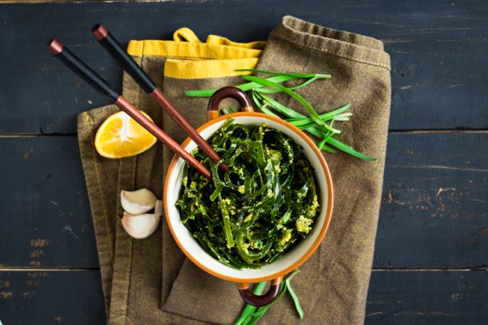 Japanese asian chuka laminaria seaweed salad with dressing of onion, garlic, lemon, sesame seeds and oil. Traditional lunch or dinner. Used to eat with chopsticks. Raw, vegan, vegetarian healthy food