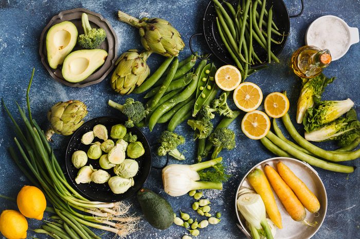 Greenery veggies composition. Variety of green vegetables and lemons. Top view.