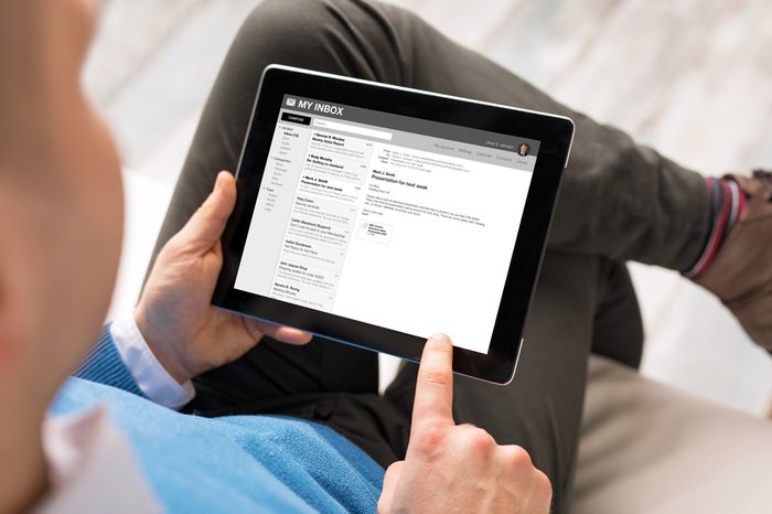 Man reading email on tablet. All content is made up.
