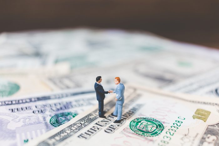 Miniature Business people with US dollar banknote background