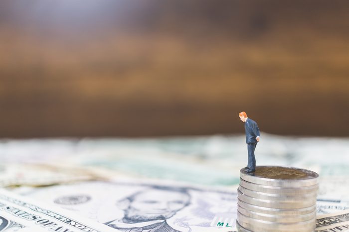 Miniature Business people with US dollar banknote background