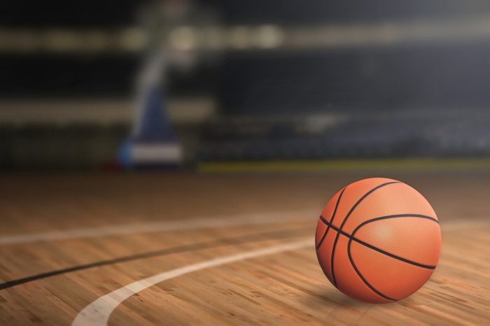 Basketball on Court Floor close up with blurred arena in background