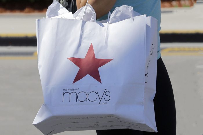 A shopper carries a bag as she walks in the parking lot of a shopping mall in Hialeah, Fla. Macy's Inc. reports earnings, Thursday, Aug. 10, 2017
