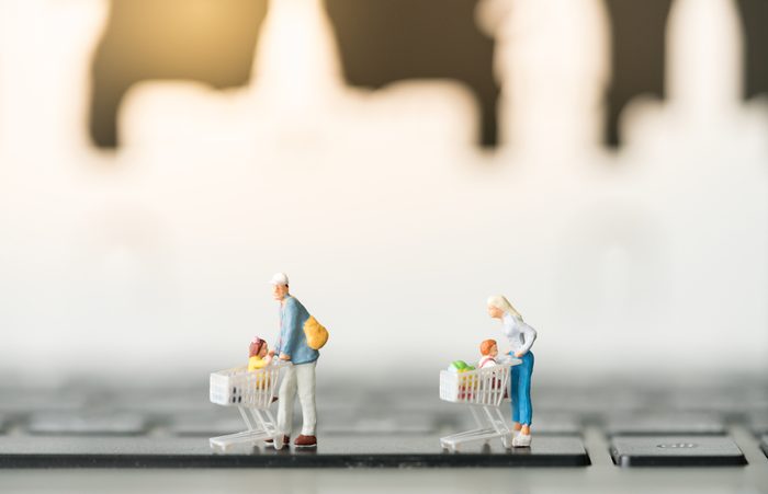 Miniature with shopping cart using as background business online concept.