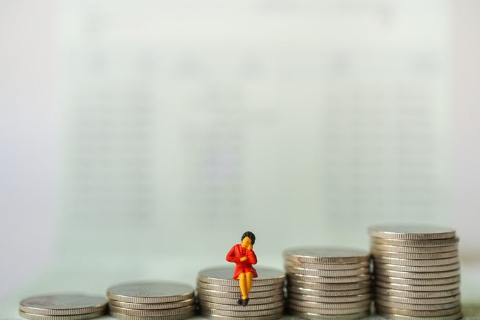 Miniature people : Business women sitting and thinking about business on stack of coins, e-commerce, online technology business concept