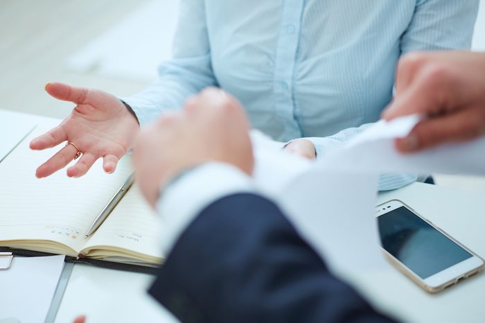 Breaking contract. Furious young businessman tearing up employment contract.