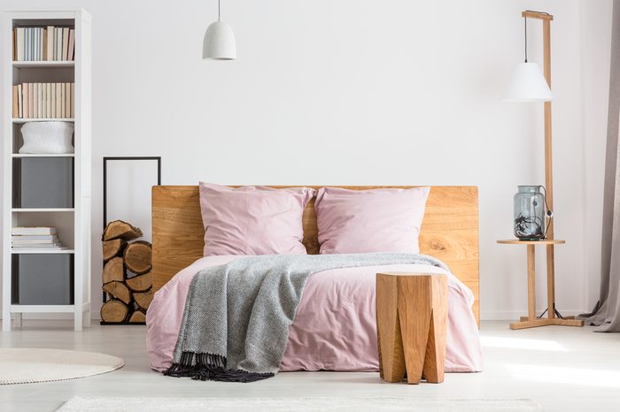 Wooden decor spacious bedroom with pink bedding and white walls