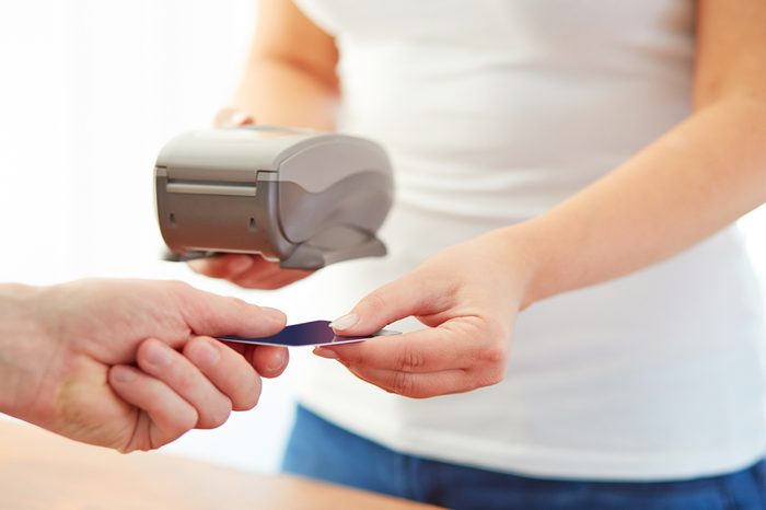 Woman accepts credit card to pay, in the store