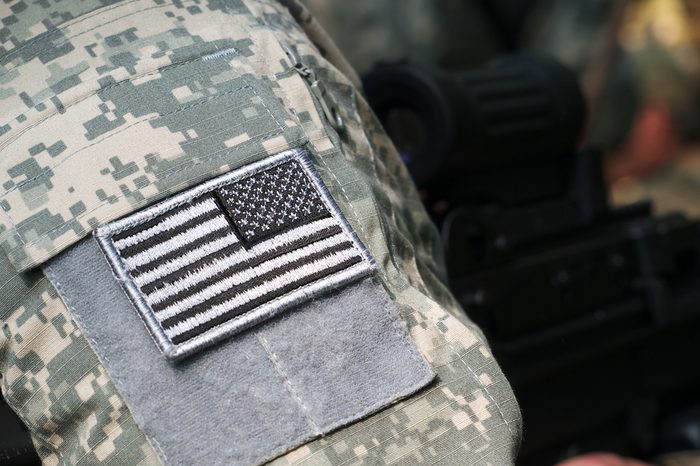 US Army uniform element - sleeve patch with flag and machine gun on the background