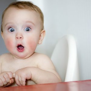 surprised kid sitting at table. child's eyes widened and mouth opened in amazement