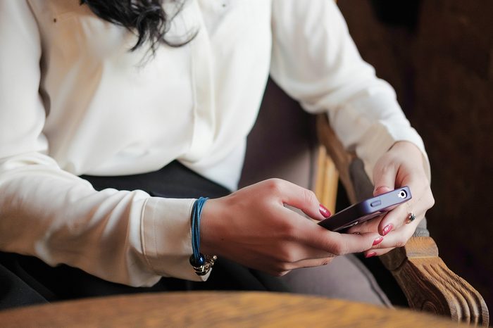 Young girl in the cafe does business. Young girl holding a smartphone. Office worker on lunch. business meeting. send a message