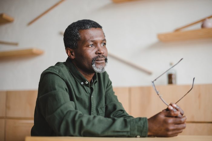 thoughtful mature african american man sitting in cafe