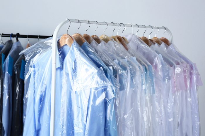 Rack of clean clothes hanging on hangers at dry-cleaning