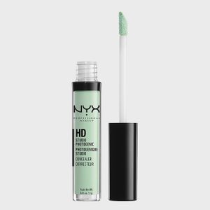 Green concealer with applicator, displayed upright, against a plain background. Text reads 