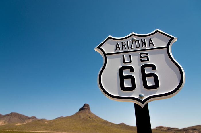 A scenic view of a historic Route 66 sign with a sky blue background
