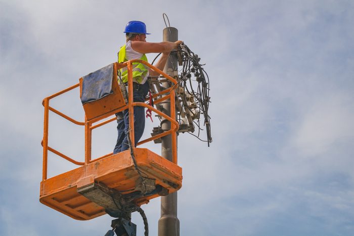 Power line worker fixing from the truck basket.