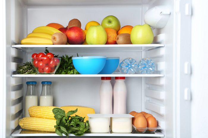 Open fridge full of vegetables and fruits