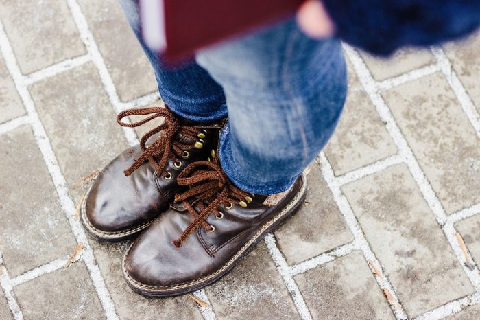 High angle view on woman's legs wearing brown shoes and blue jeans