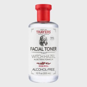 Bottle displaying facial toner with witch hazel, aloe vera, rose petal scent, featuring red cap, labeled 