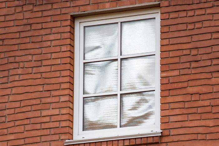 Foil in the window of red brick private house to reflect the summer sun