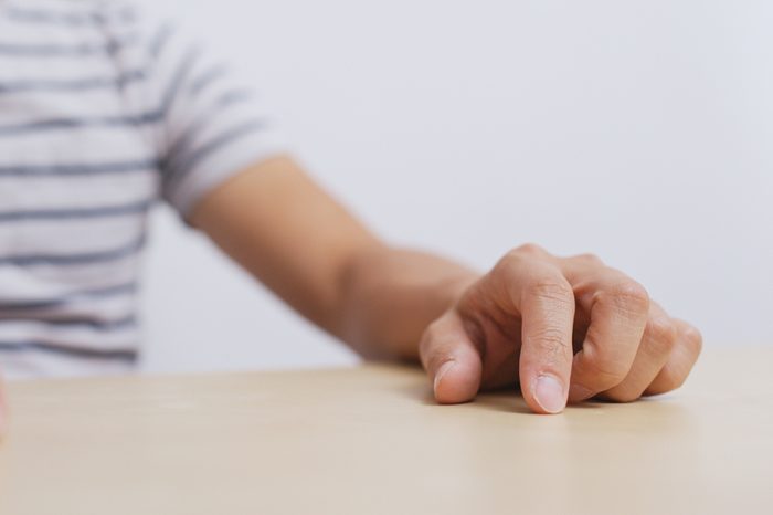 Adult man hand finger tapping on table 