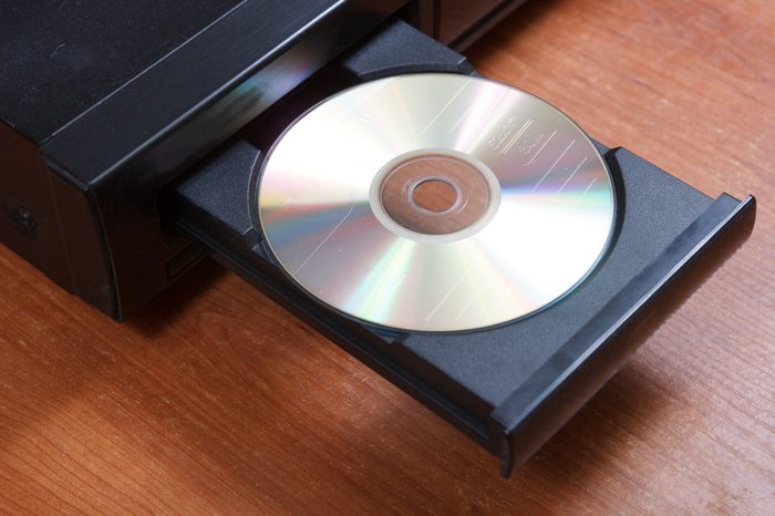 cd in retro cd player opened tray on brown table