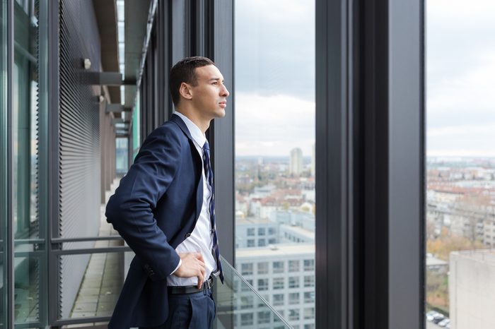 Business man looking out through the office balcony.