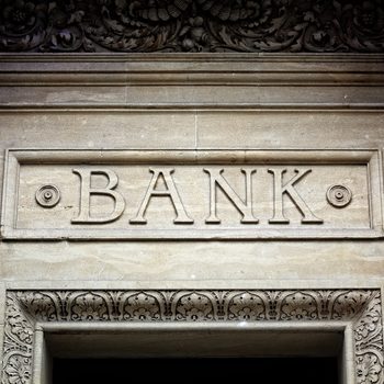Old bank sign engraved in stone or concrete above the door of financial building concept for finance and business
