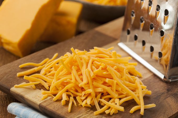 Organic Shredded Sharp Cheddar Cheese on a Cutting Board