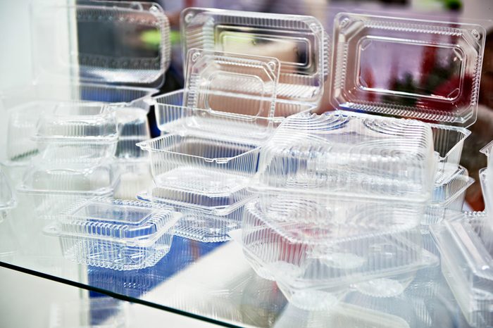 Plastic disposable food containers in showcase of shop