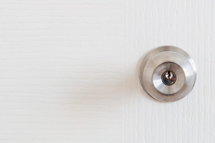 Detail of a metallic knob on white door , tainless steel round ball door knob