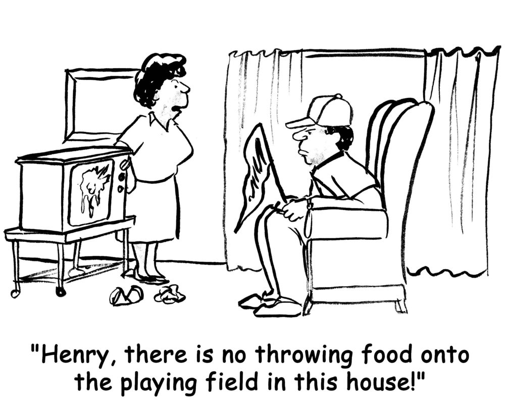 Man sits in a chair holding a paper, woman by a TV scolds him for throwing food, crumpled items on the floor. Text: "Henry, there is no throwing food onto the playing field in this house!"
