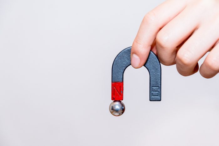 Close up of male hand holding horseshoe magnet